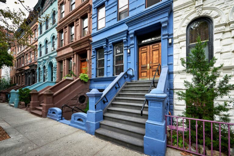 a row of brownstone buildings and stoops in an iconic neighborhood